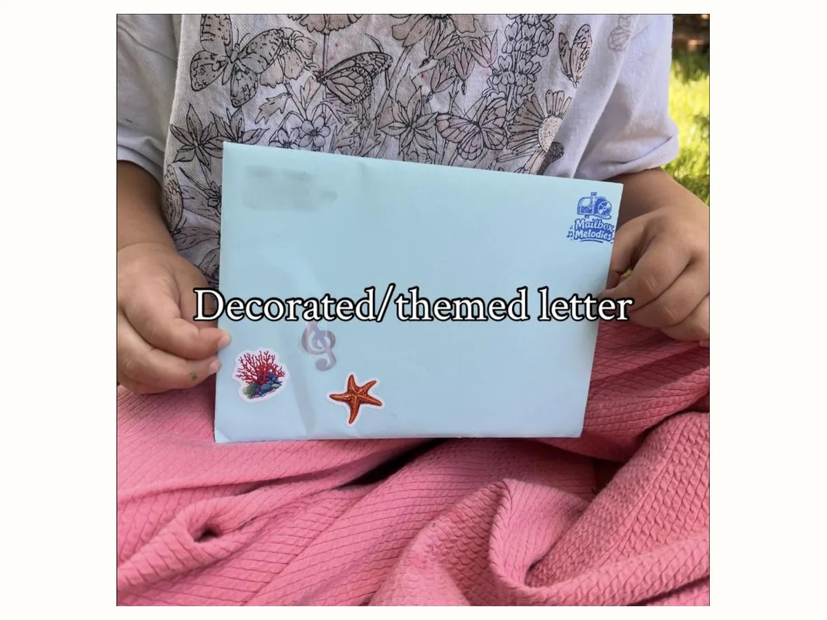 A decorated, themed Mailbox Melodies envelope addressed to a child, with sea stickers on the front